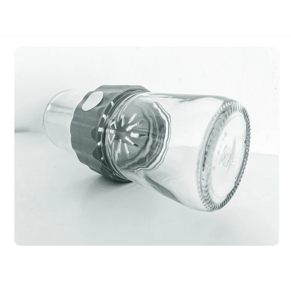 A Plant Cell Biocoupler™ Glass Set (16oz, 12oz, 8oz) glass is placed upside down over a citrus juicer reamer on a white surface.