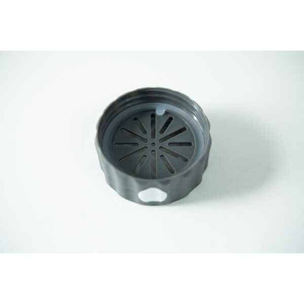 A black, round plastic lid with a slotted vent pattern, designed for the Plant Cell Biocoupler™ Glass Set (16oz, 12oz, 8oz), is shown on a white surface.