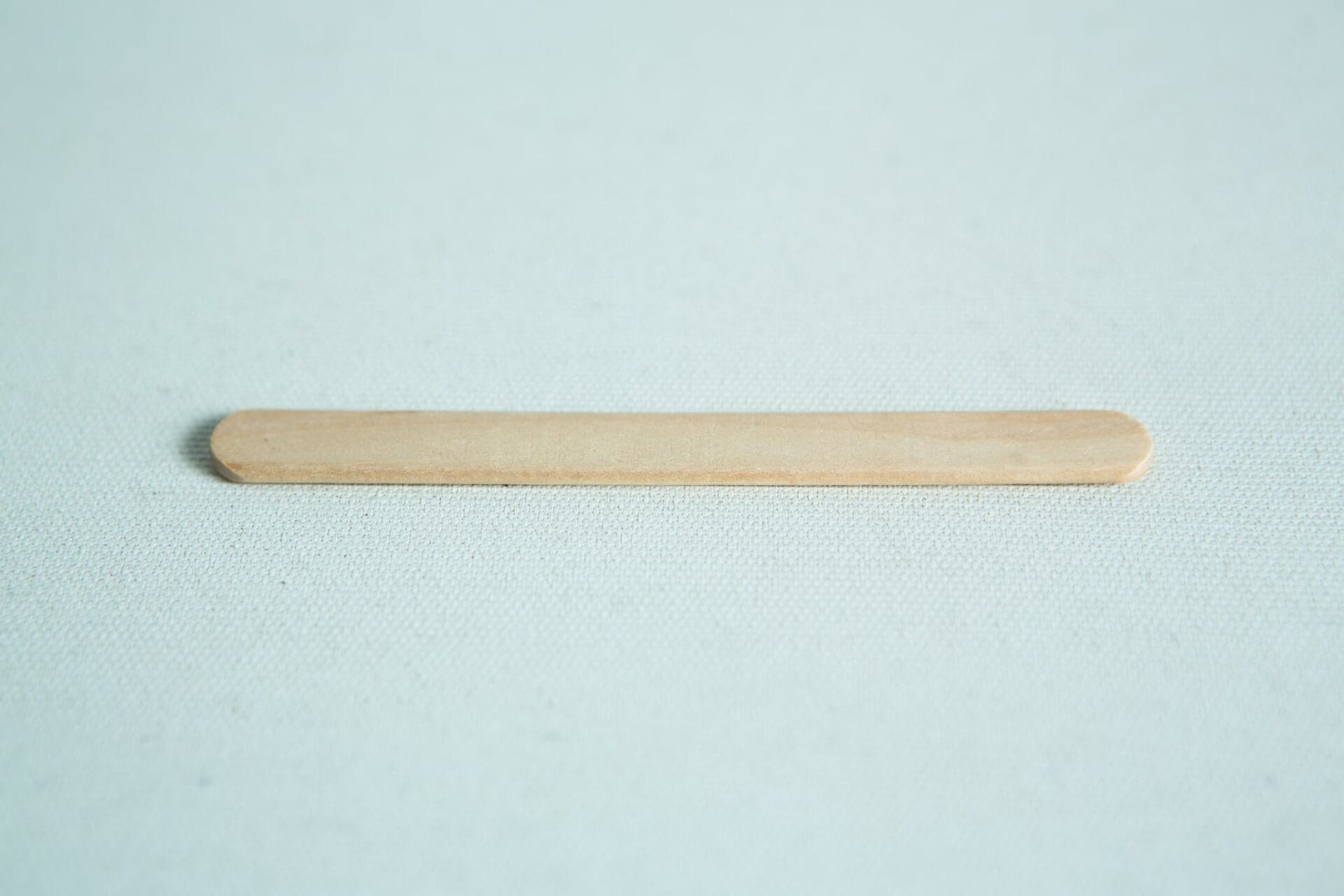 Birch hardwood sticks for slants 3 A Paddle Pop stick rests flat on a lightly textured surface.