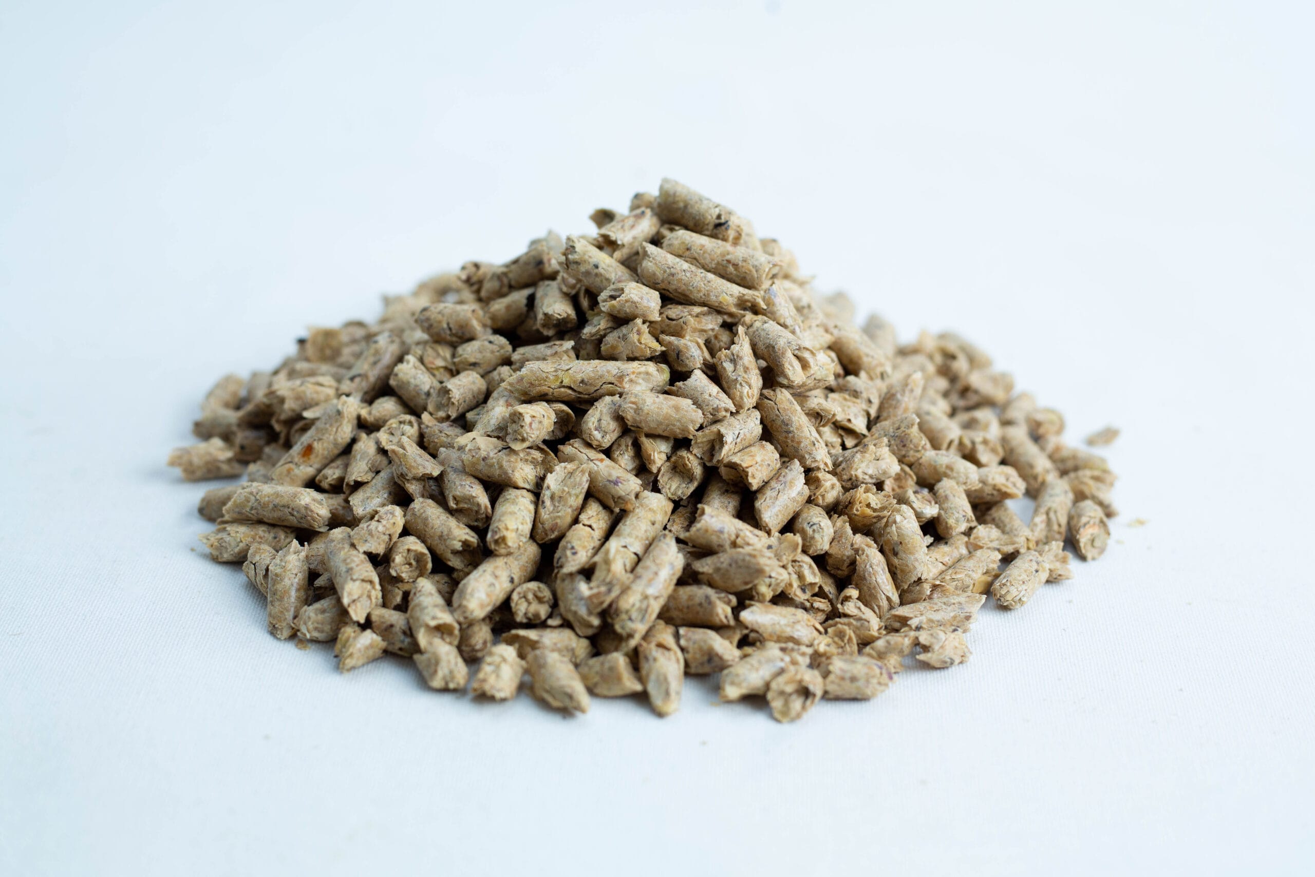 Lupin Hull Pellets 100% Non-GMO 20KG Australian Grown | Rootlab 2 A pile of beige cylindrical Lupin Hull Pellets 100% Non-GMO, Australian grown, is shown on a white background.