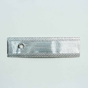 A rectangular metallic strip with a small round hole near one end, placed on a plain white background.