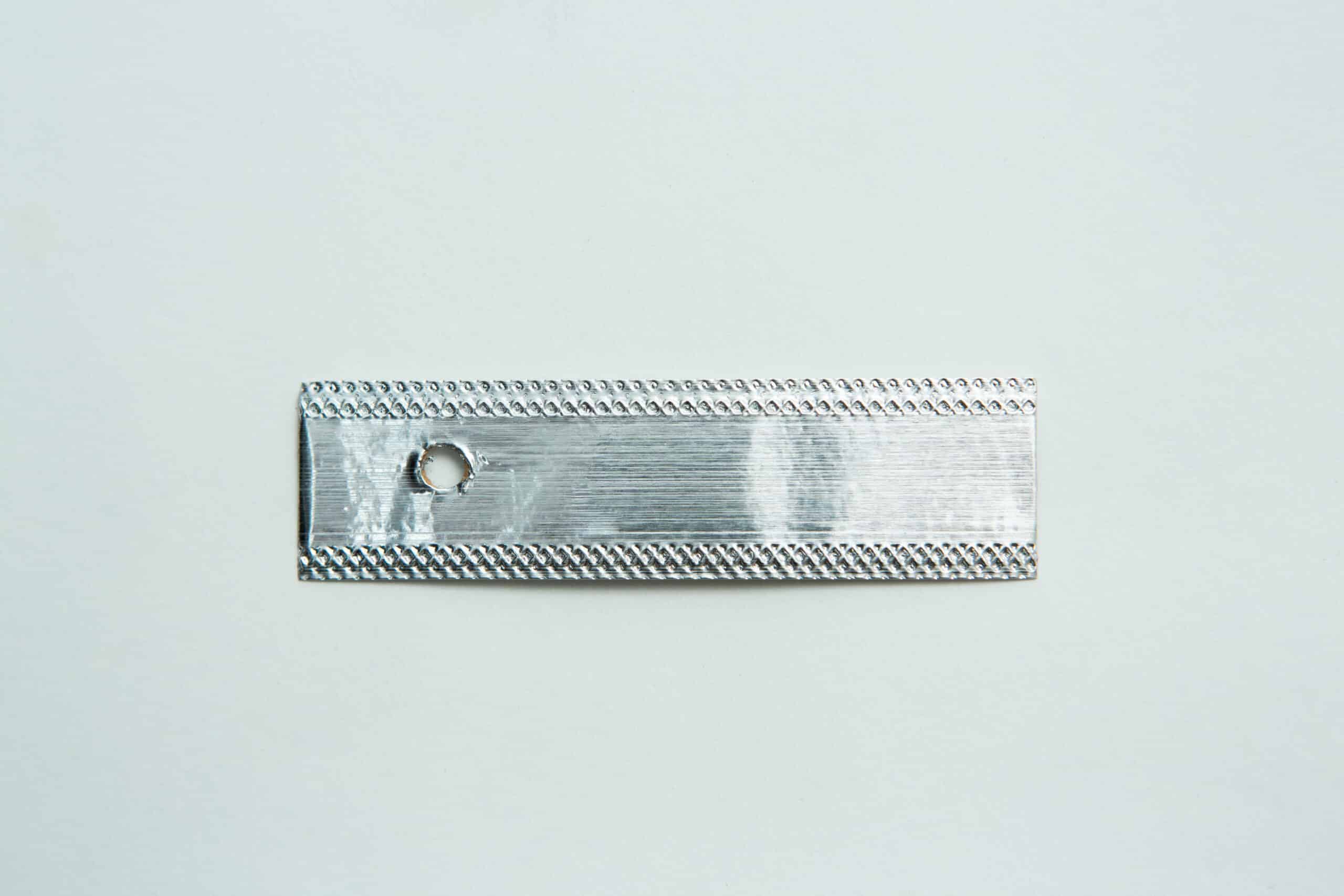Aluminium Log Labelling Tags - Weather Safe 1 A rectangular metallic strip with a small round hole near one end, placed on a plain white background.