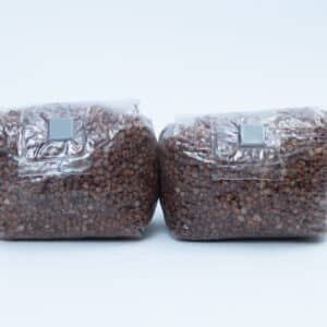 Canberra 5 Two sealed plastic bags filled with brown grains, placed side by side on a plain white background.