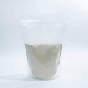 A clear resealable bag filled halfway with a light beige powder, set against a white background.